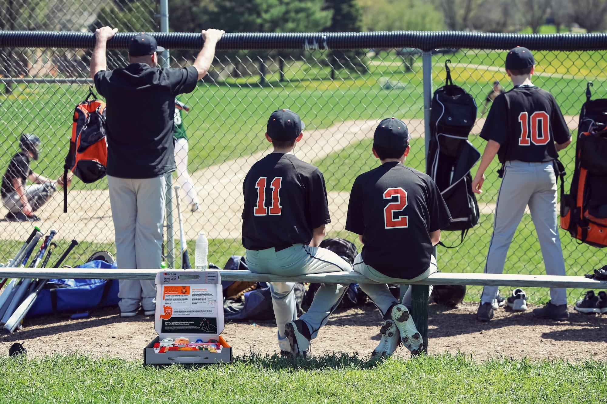 Baseball players in a dugout with equipment and gear.
