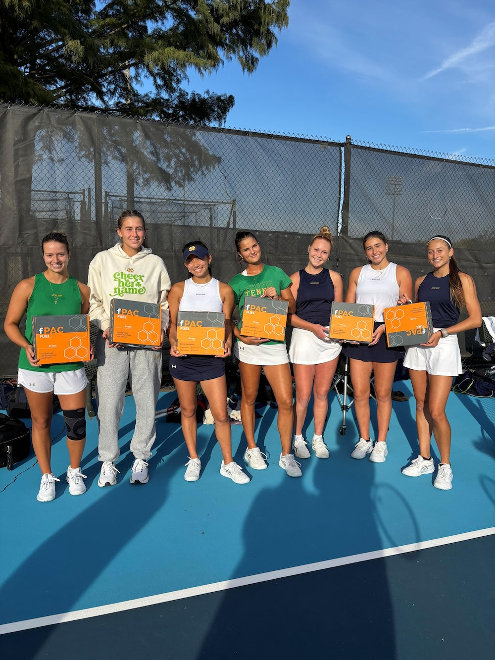 Group of tennis players holding trophies on a tennis court