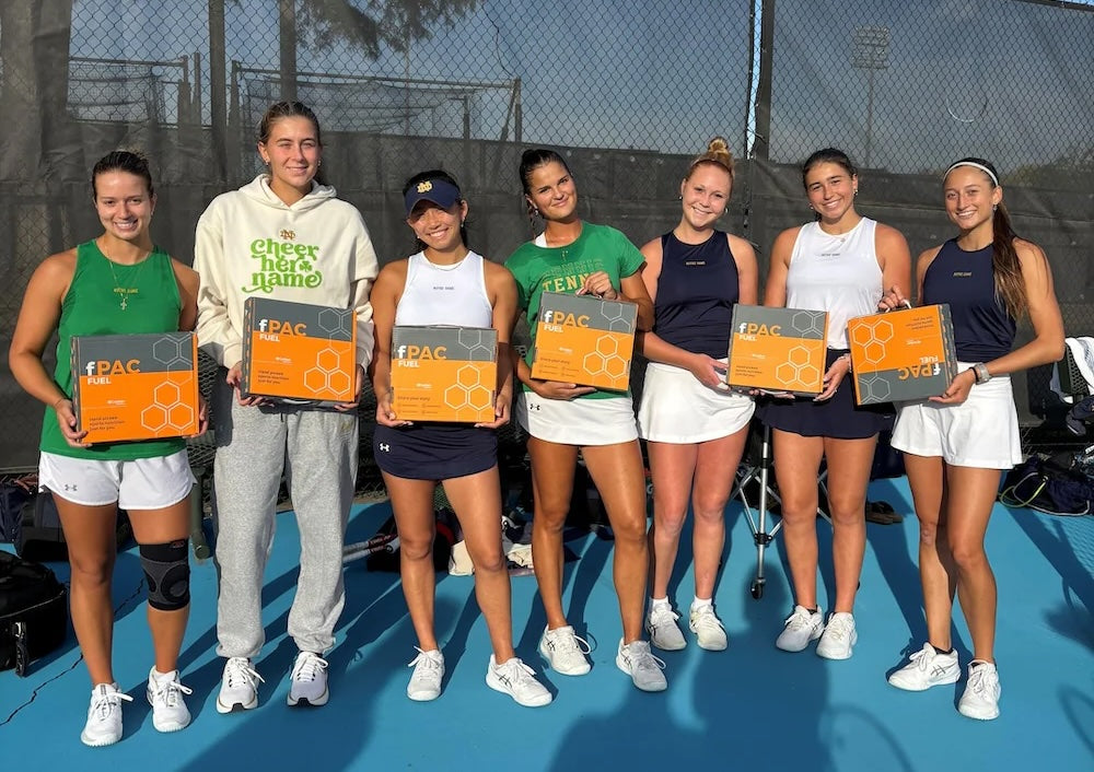 Group of women holding boxes on a tennis court