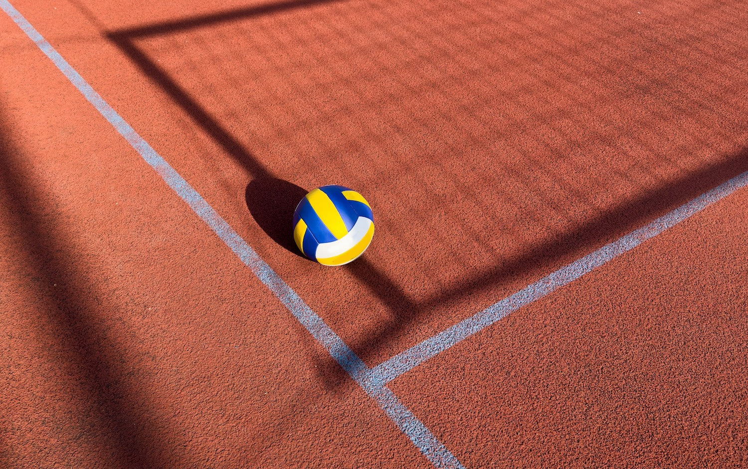 Volleyball on a red court with white lines